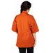 A woman wearing an orange Uncommon Chef Venture Pro Vent chef coat.