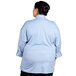 A woman in a light blue Uncommon Chef long sleeve chef coat with a mesh back.