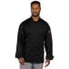 A man wearing a black Uncommon Chef Endeavor Pro Vent long sleeve chef coat with mesh back.