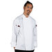A man in a white Uncommon Chef long sleeve chef coat with mesh back posing for a photo.