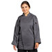 A woman wearing a Uncommon Chef slate grey long sleeve chef coat with mesh back.