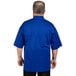 A man wearing a deep royal blue Uncommon Chef Venture Pro Vent short sleeve chef coat with mesh back.