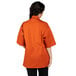 A woman wearing an orange Uncommon Chef Venture Pro chef coat.