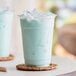 A close up of a Capora Cotton Candy Frappe with a blue liquid and foam on top.