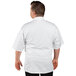 A man wearing a white Uncommon Chef short sleeve chef coat with a white collar.