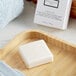 A white Beekman Fresh Air bar soap on a wooden tray.