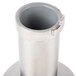 A metal bell cover with a hole over a metal pipe.