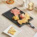 An Acopa faux slate melamine serving board with food on it.