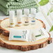 A group of EcoLOGICAL .75 oz. body wash bottles on a wood slice.