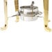 A Vollrath Classic Brass Coffee Urn with a metal pot on a table outdoors.