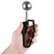 A hand using a Zeroll black EZ squeeze handle.