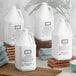 A group of Beekman 1802 Fresh Air gallon jugs on a wooden shelf.