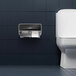 A Kimberly-Clark Professional ICON Coreless Standard Roll Horizontal Toilet Paper Dispenser with a black mosaic design faceplate on a wall above a toilet.