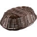 A brown oval rattan basket on a white background.