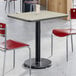 A rectangular standard height table with a reversible gray and white laminated top and a black cast iron base.