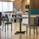 A Lancaster Table and Seating white table and base in a restaurant dining area.