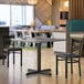 A Lancaster Table & Seating reversible gray and white table top with a white cup on it.