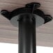 A black metal table base with a Lancaster Table & Seating white birch table top.