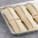 A tray with six Orange Bakery almond filled croissants ready to bake.