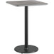 A square table with a black pole and gray surface on a black base.