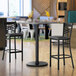 A Lancaster Table & Seating gray and white laminated bar height table with a black base.