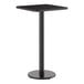 A square, bar-height table with a black laminated top and a round cast iron base.