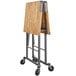 A Cosco portable folding workbench with a wooden top and wheels.