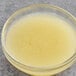 A clear bowl of yellow Les Vergers Boiron Bergamot fruit puree with a spoon in it.