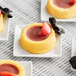 A group of small white plates with Les Vergers Boiron Dark Red Plum fruit puree desserts.