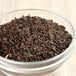 A bowl of Twinings Earl Grey loose dried tea leaves on a wooden table.