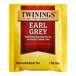 A yellow Twinings Earl Grey tea packet with a red label.