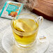 A Twinings Soothe Turmeric, Orange & Star Anise herbal tea bag in a glass cup of tea.