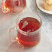 A glass mug of Twinings Irish Breakfast Tea next to a plate of muffins.