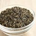 A bowl of Twinings Jasmine Green Loose Leaf Tea on a wooden table.