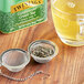 Loose Twinings Gunpowder Green tea steeping in a strainer over a cup of tea.