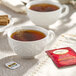 A cup of Twinings English Breakfast Decaffeinated tea with a tea bag on the saucer.