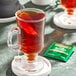 A glass cup of Twinings Irish Breakfast decaffeinated tea with a tea bag in it.