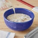 A bowl of food with evaporated milk being poured into it.