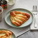 A plate with two Schulstad Lemon Creme Fan Danish pastries on it.