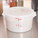 A white Cambro round plastic food storage container with a lid.