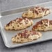 A tray of four Schulstad chocolate hazelnut filled croissants on a gray surface.