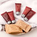 A tray with small bottles of Ecossential Naturals hotel conditioner, lotion, body wash, and shampoo.