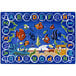 A white rectangular area rug with a blue border, blue letters, and underwater scenes including fish.