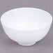 A white GET Water Lily melamine bowl with a white rim on a gray surface.