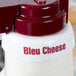 A white Tablecraft plastic collar with maroon lettering that says "Bleu Cheese"