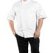 A man wearing a Uncommon Chef white short sleeve chef coat with a mesh back.