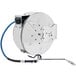 A T&S stainless steel hose reel with a hose attached to it.