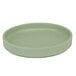 A close-up of a green Cal-Mil melamine plate with a circular rim.