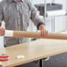 A man holding a Lavex kraft mailing tube on a table.