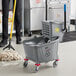 A man using a Lavex mop and bucket to clean a floor.